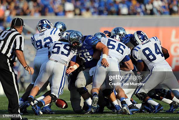 Chris Schuetz of the Memphis Tigers looks to recover a fumble against Justin Foxx, Kelby Brown, Kyler Brown and Kenny Anunike of the Duke Blue Devils...