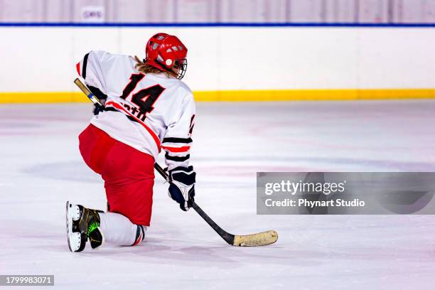 trying to get off the ground, one knee on the ground, female ice hockey player - defenseman ice hockey stock pictures, royalty-free photos & images