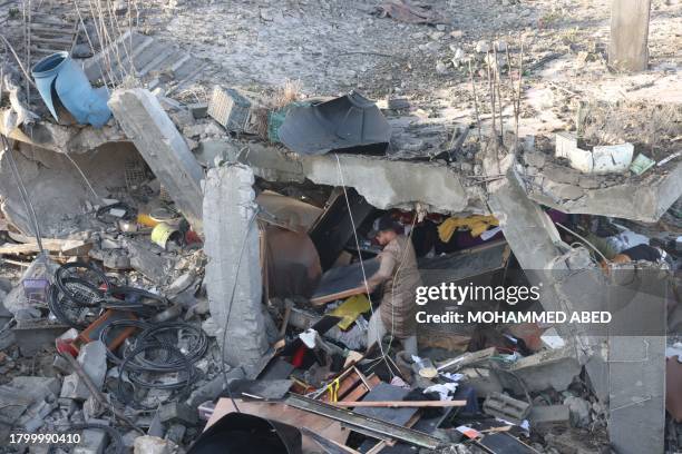 Man salvages objects amid rubble of a school hit during an Israeli strike before the start of a four-day truce in the battles between Israel and...