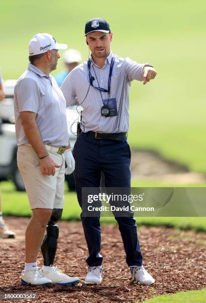 Mike Browne of England gets a ruling from G4D Tour referee Richard Warren of England as he prepares to play his fourth shot on the 18th hole during...