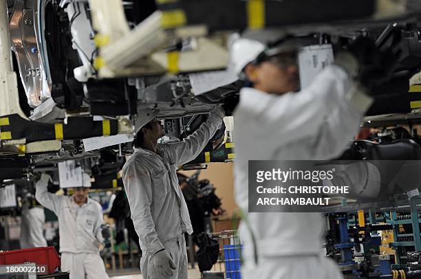 To go with Thailand-economy-auto,FOCUS by William Davis This picture taken on June 18, 2013 shows employees working on a car assembly line at a Honda...