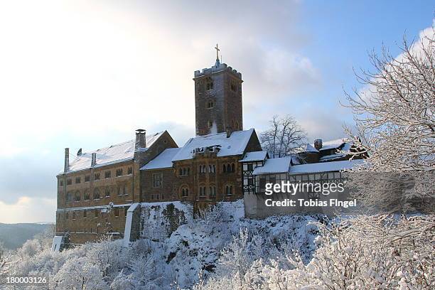 Wartburg Castle, near the little town Eisenach, caught in a bright Winter day with sun, covered by snow. It was in this castle that Luther went into...