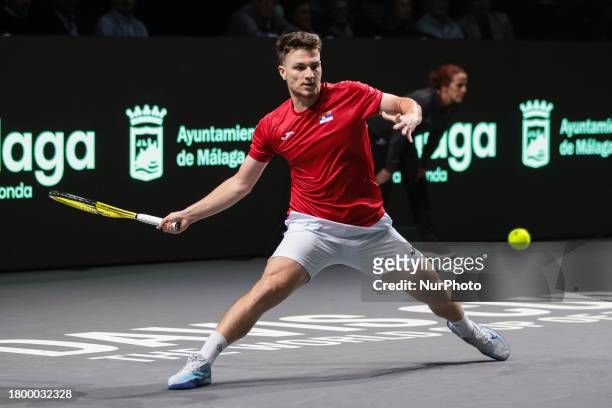 Miomir Kecmanovic of Serbia is playing a forehand during the quarterfinal match against Jack Draper of Great Britain at the Davis Cup in Malaga,...