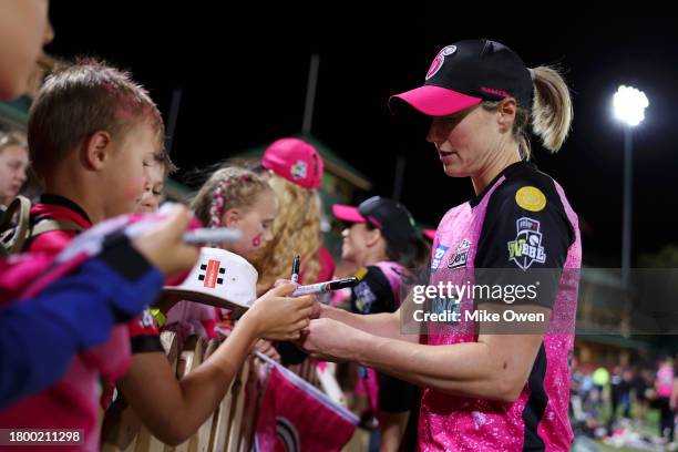 Ellyse Perry of the Sixers signs autographs for fans following the team's defeat in the WBBL match between Sydney Sixers and Adelaide Strikers at...