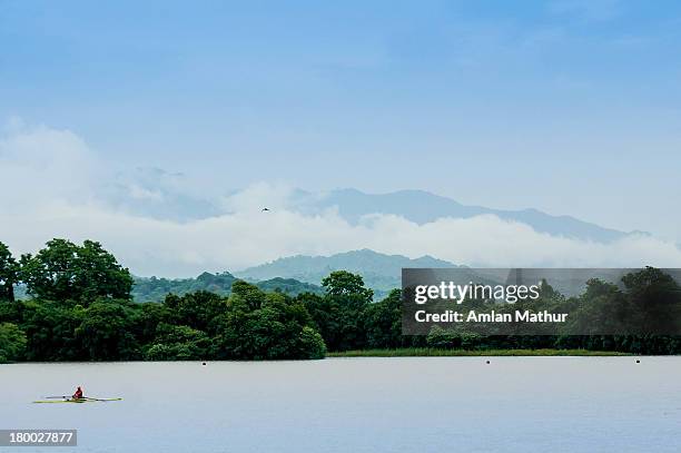 canoe on a lake against cloud covered hills - chandigarh stock pictures, royalty-free photos & images