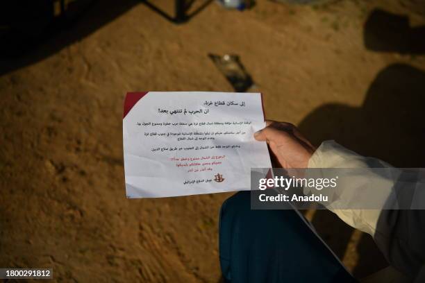 View of a leaflet dropped by Israeli forces to warn Palestinians against moving to north of Gaza during humanitarian pause in Rafah, Gaza on November...