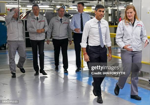 Britain's Prime Minister Rishi Sunak and Britain's Chancellor of the Exchequer Jeremy Hunt walk with Nissan President & CEO Makoto Uchida and Nissan...