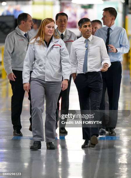 Britain's Prime Minister Rishi Sunak and Britain's Chancellor of the Exchequer Jeremy Hunt walk with Nissan President & CEO Makoto Uchida and Nissan...