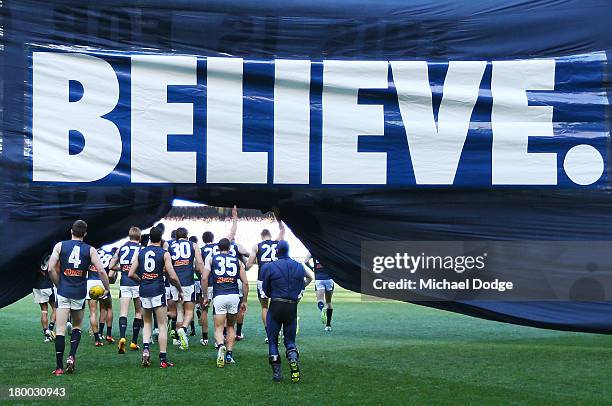 The Blues players run through their banner during the First Elimination Final AFL match between the Richmond Tigers and the Carlton Blues at...