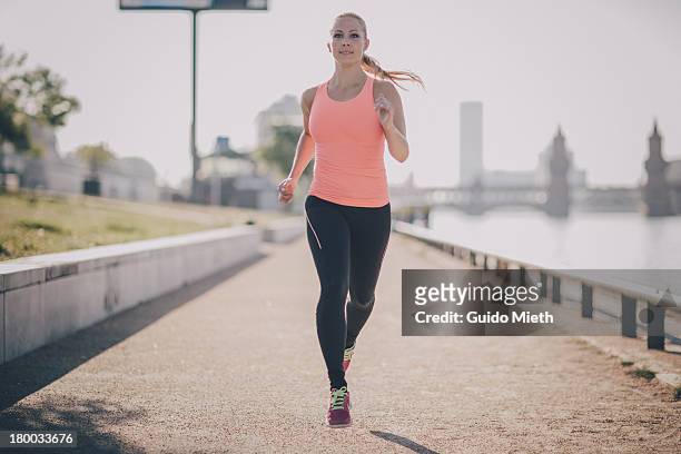 woman running in urban scene. - jogging stock-fotos und bilder