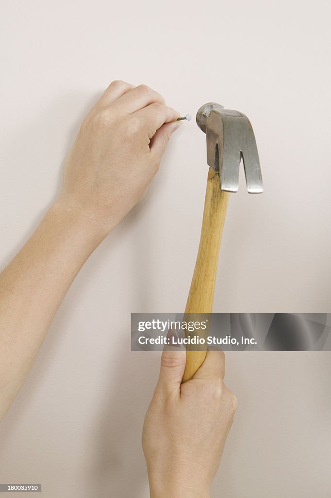 Woman Hammering A Nail Into A Wall High-Res Stock Photo - Getty Images Woman Hammering A Nail Into A Wall High-Res Stock Photo - Getty Images