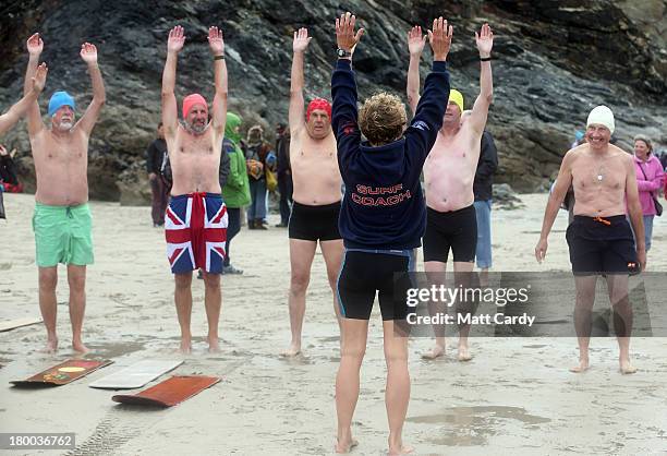 Belly boarders warm up on the beach prior to taking part in a senior mens heat during the annual World Belly Boarding Championships at Chapel Porth...