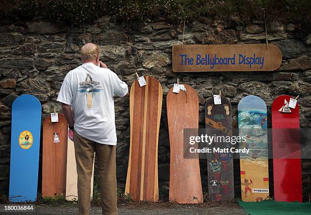 Man looks at vintage bellyboards displayed at the annual World Belly Boarding Championships at Chapel Porth on September 8 2013 in Cornwall, England....