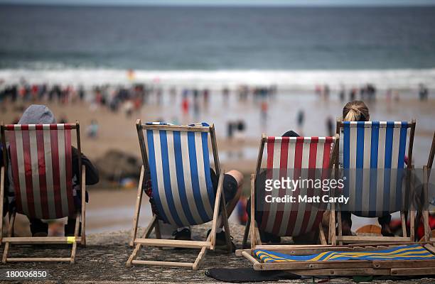 People sit in traditional deck chairs as they watch the annual World Belly Boarding Championships at Chapel Porth on September 8 2013 in Cornwall,...