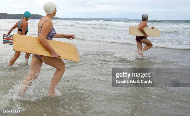 Belly boarders run into the sea to take part in a senior ladies heat during the annual World Belly Boarding Championships at Chapel Porth on...