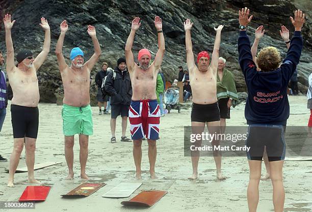 Belly boarders warm up on the beach prior to taking part in a senior mens heat during the annual World Belly Boarding Championships at Chapel Porth...
