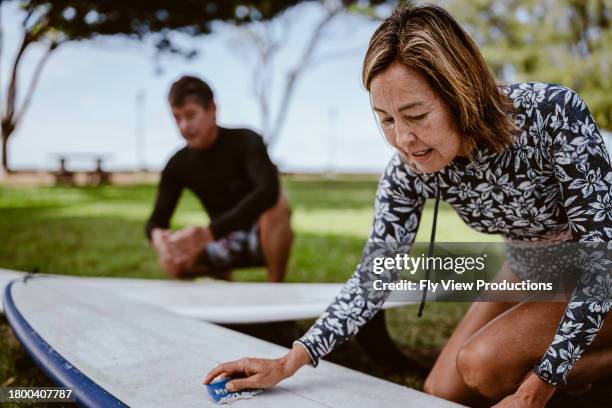 active multiracial senior woman going surfing with her brother - pacific ocean stock pictures, royalty-free photos & images