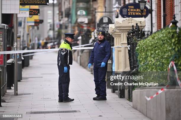 Police officers stand near the crime scene from yesterdays stabbing on November 24, 2023 in Dublin, Ireland. Vehicles were set alight and shops...