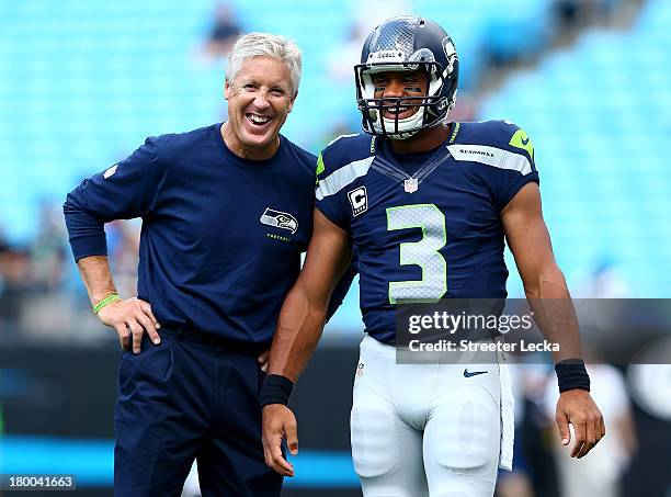 Head coach Pete Carroll of the Seattle Seahawks talks with his quarterback Russell Wilson of the Seattle Seahawks before their game against the...