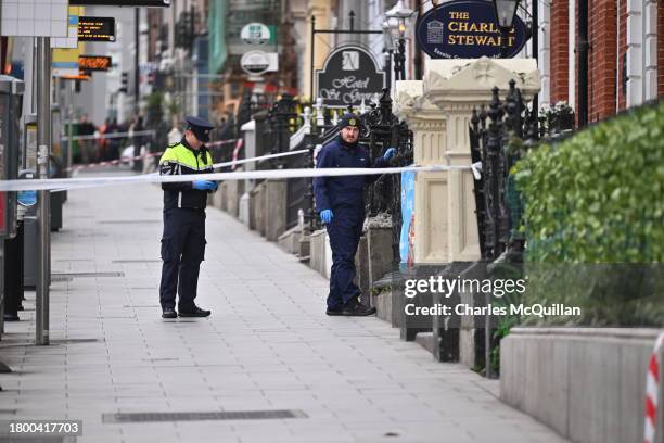 Police officers stand near the crime scene from yesterdays stabbing on November 24, 2023 in Dublin, Ireland. Vehicles were set alight and shops...