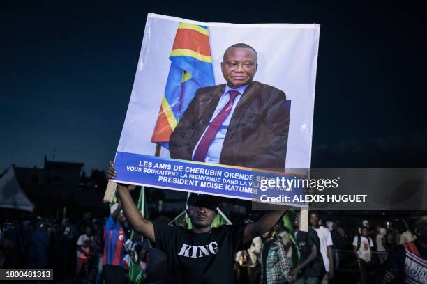 Man carries a poster in memory of Cherubin Okende, a close associate of Moise Katumbi who was murdered in July 2023 under murky circumstances, during...