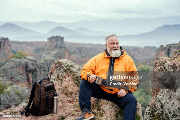 mature bearded tourist hiking in the mountains - range of coffees stock pictures, royalty-free photos & images