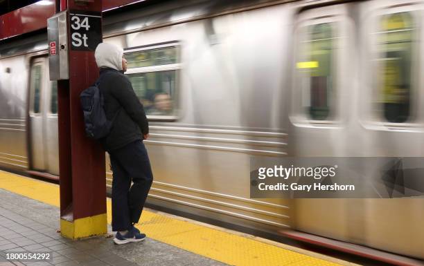 Person waits on a platform to board a subway train at the 34th Street - Herald Square station on November 16 in New York City.