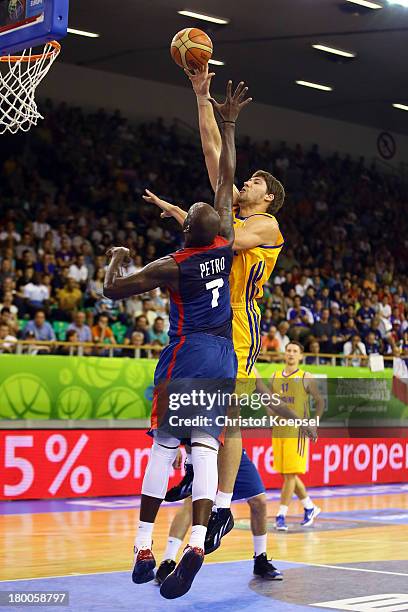 Viacheslav Kravtsov of Ukriane shoots over Johan Petro of France during the FIBA European Championships 2013 first round group A match between...