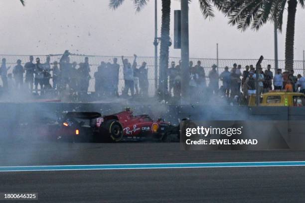 Ferrari's Spanish driver Carlos Sainz Jr crashes into the wall during the second practice session for the Abu Dhabi Formula One Grand Prix at the Yas...