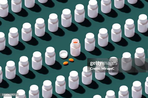 opened pill bottle among many other sealed bottles - recipiente para las píldoras fotografías e imágenes de stock