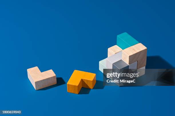 pieces of wooden puzzle on blue background - cube shape stock pictures, royalty-free photos & images