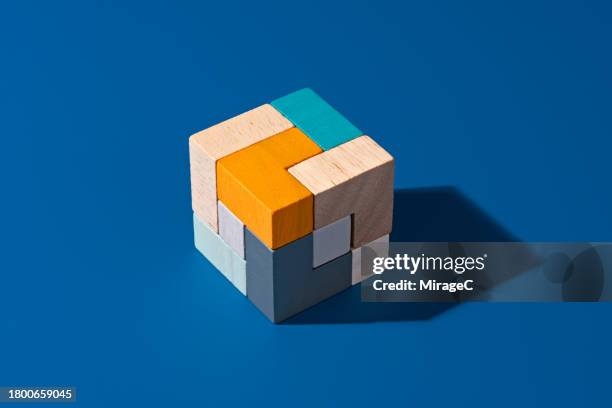 completed wooden puzzle on blue background - rubiks kub bildbanksfoton och bilder