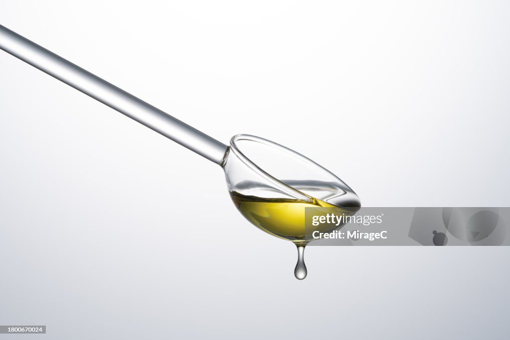 Transparent Glass Spoon Filled With Olive Oil