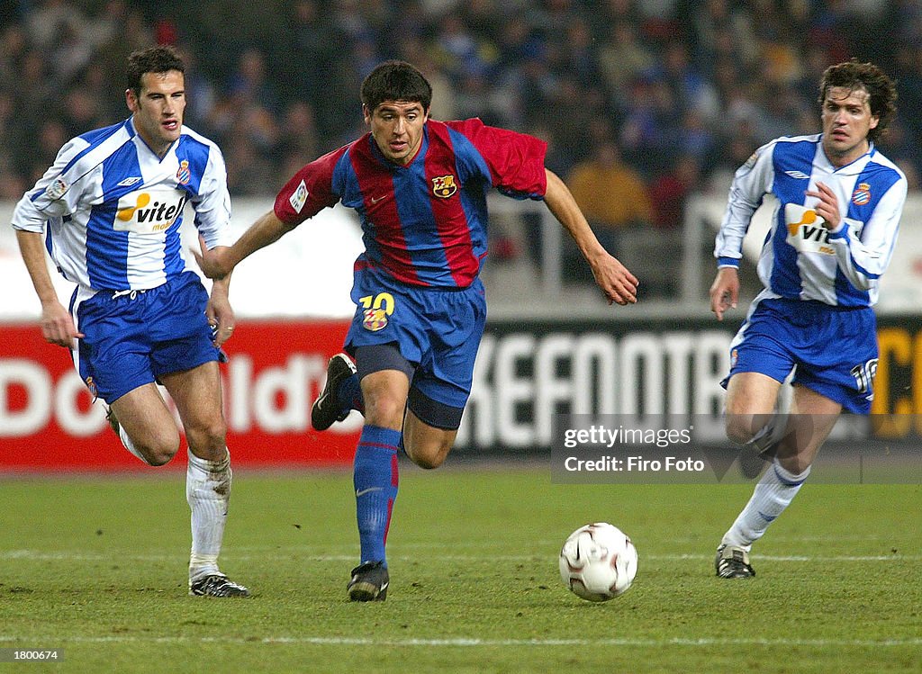 Riquelme of Barcelona runs between Alberto Lopo (L) and Roger