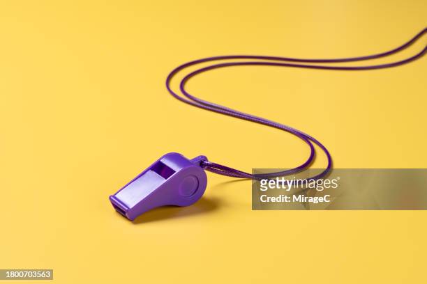 purple whistle with lanyard on yellow background - pfeife stock-fotos und bilder