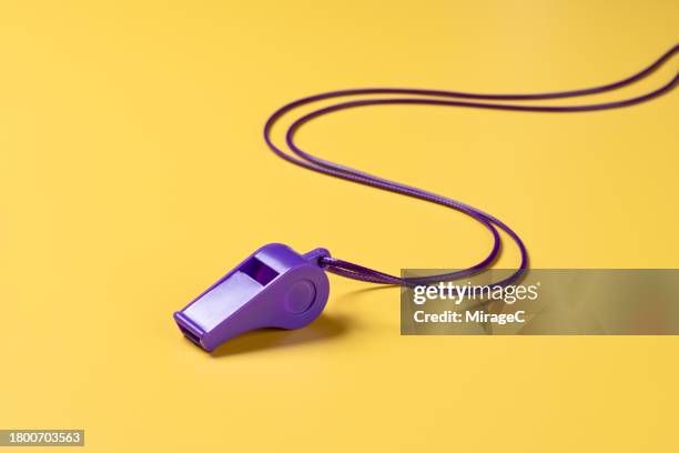 purple whistle with lanyard on yellow background - falta término deportivo fotografías e imágenes de stock