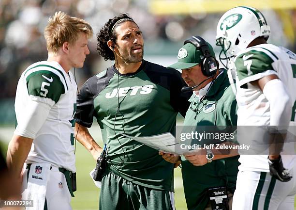 Matt Simms, Mark Sanchez of the New York Jets and Geno Smith of the NEw York Jets confer with offensive coordinator Marty Mornhinweg during their...