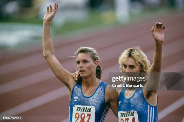 German athlete Katrin Krabbe and German athlete Heike Drechsler, both competing for East Germany, way to the crowd after the women's 200m final of...