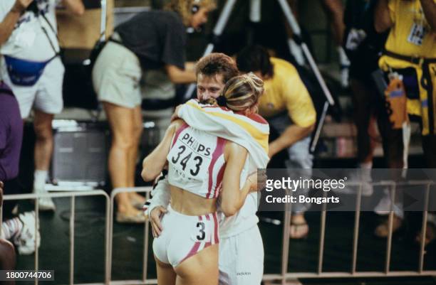 German athlete Katrin Krabbe is embraced by German athletics coach Thomas Springstein at the 1991 IAAF World Championships, held at the National...
