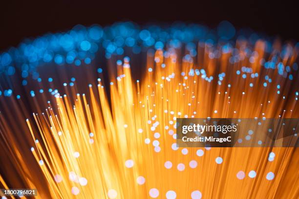 illuminated fiber optics by blue and orange light, data concept - fibra ottica foto e immagini stock