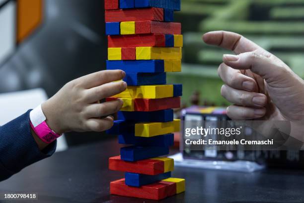 Child and his father play Jumbling Tower during the "Entraingioco" Festival at Superstudio Maxi on November 18, 2023 in Milan, Italy. "Entraingioco"...