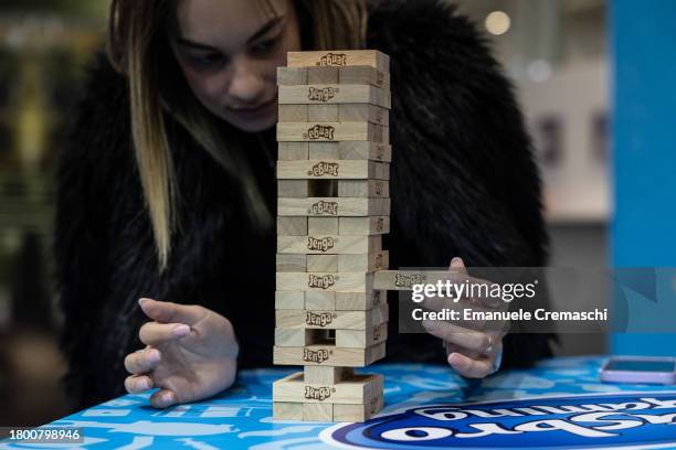 Woman plays Jenga during the "Entraingioco" Festival at Superstudio Maxi on November 18, 2023 in Milan, Italy. "Entraingioco" is a brand new trade...