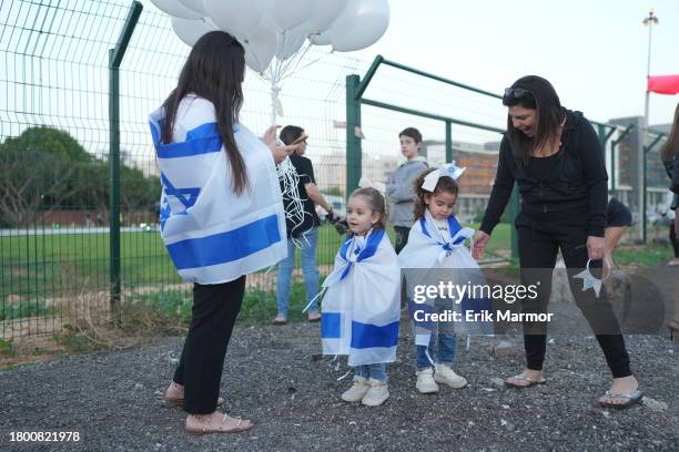 Spectators wearing Israeli flags stand outside the Schneider medical centre, where it is believed some of the released hostages may be brought, on...