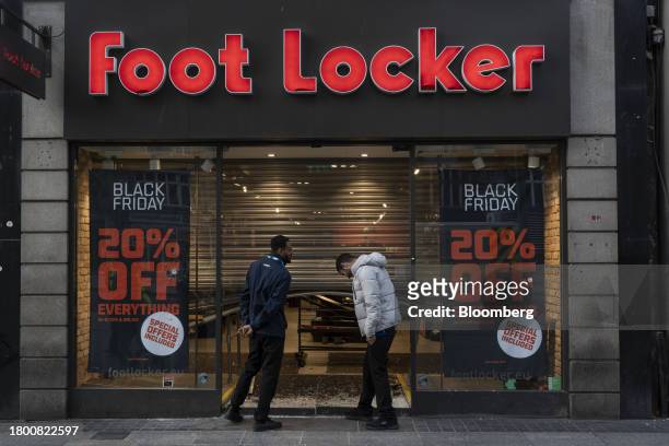 Employees inspect the damaged entrance to a Foot Locker Inc. Shop, following a night of riots, in Dublin, Ireland, on Friday, Nov. 24, 2023. Irish...