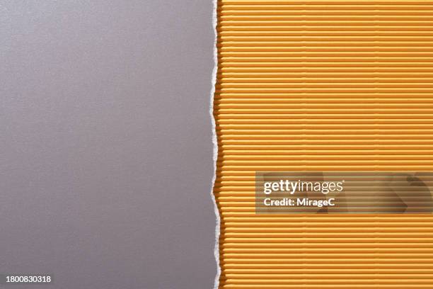 torn gray paper on yellow corrugated paper half by half - halved stock pictures, royalty-free photos & images