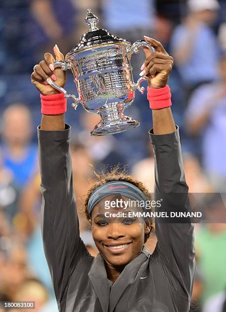 Tennis player Serena Williams holds her trophy after winning against Belarus Victoria Azarenka during the 2013 US Open women's final at the USTA...