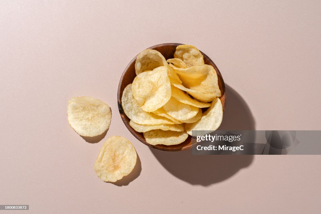 Bowl of Potato Chips on Brown Background
