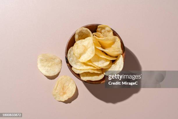 bowl of potato chips on brown background - fried potato stock pictures, royalty-free photos & images