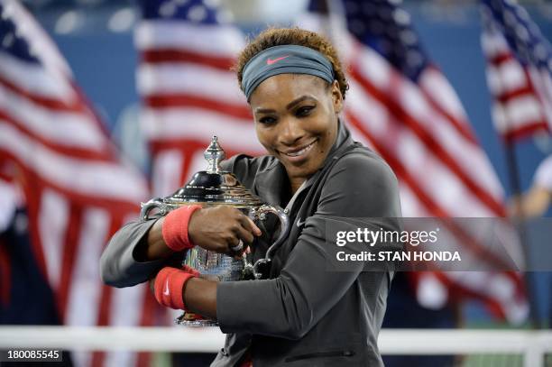 Serena Williams of the US holds the trophy as she celebrates her win over Victoria Azarenka of Belarus during their 2013 US Open women's singles...