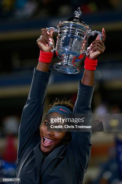 Serena Williams of the United States smiles as she poses with the trophy after winning her women's singles final match against Victoria Azarenka of...